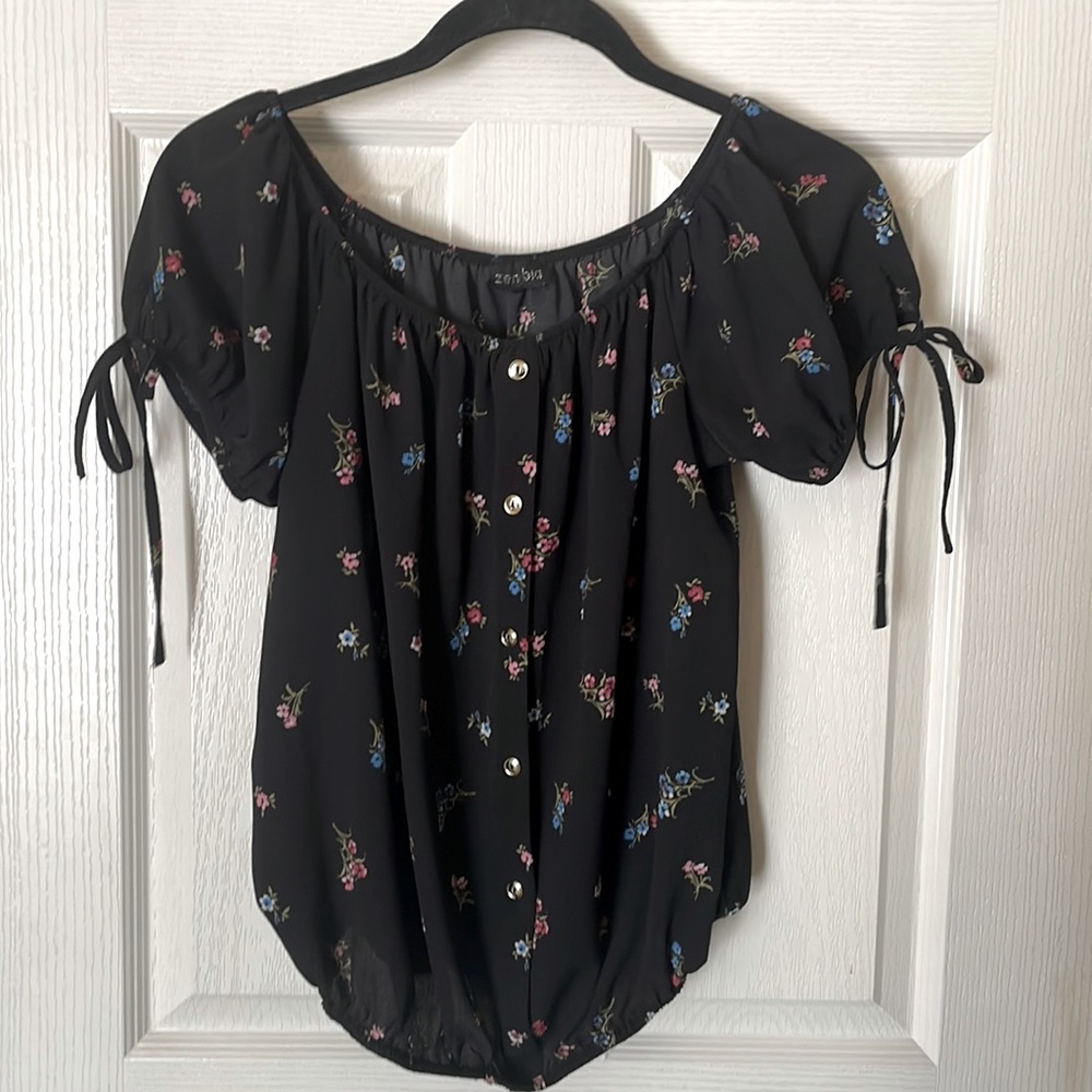 Black blouse with floral pattern.